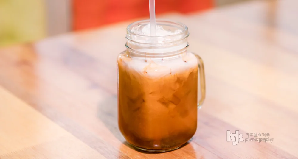 Iced drink served in a glass mason jar with a straw.