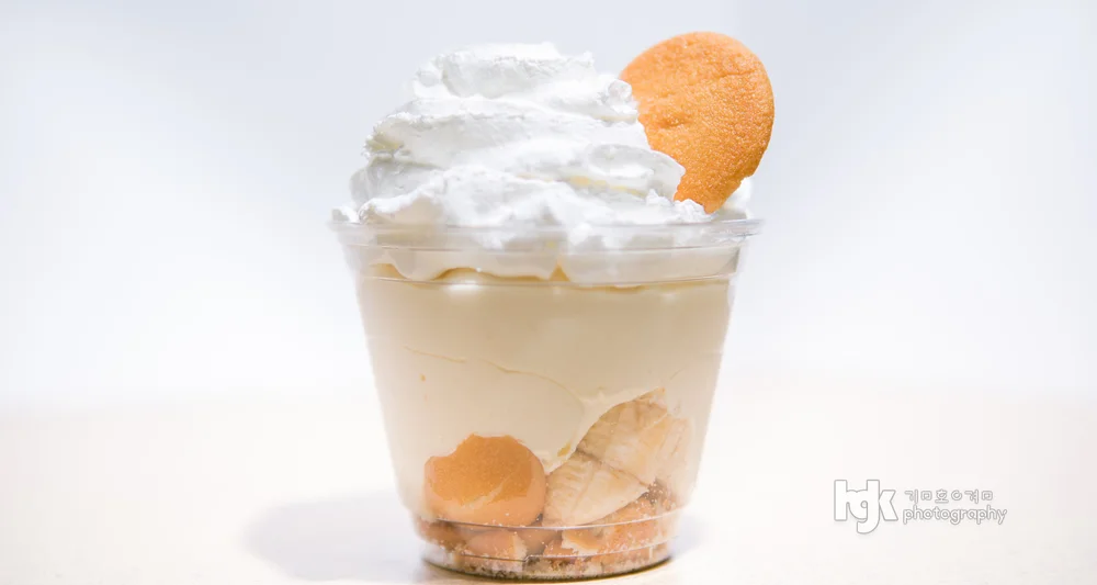 Dessert cup topped with whipped cream and a round cookie.
