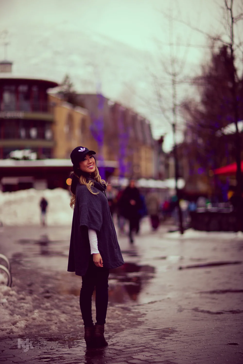 Street portrait of a person in a black cap on a snowy pedestrian street.
